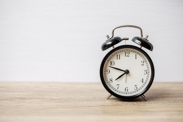 Vintage alarm clock on wooden table background and copy space for text. Activity, daily routine, morning, workout and Work life balance concept