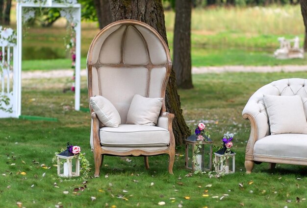 Vintage armchair in a beautiful Park surrounded by lanterns with candles decorated with flowers