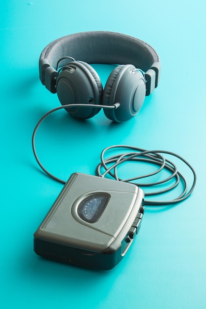 The vintage audio player and headphones on blue background