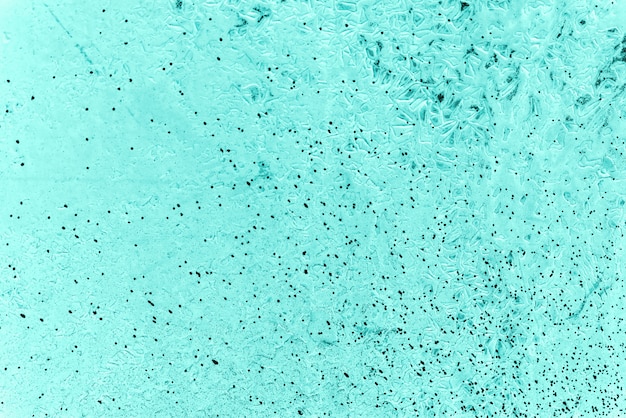 Vintage azure background. Rough painted wall of turquoise color. Imperfect plane of cyan colored. Uneven old decorative toned backdrop of aqzure tint. Texture of teal hue. Ornamental stony surface.