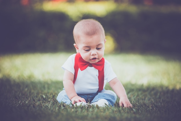 Photo vintage baby boy with red suspender in outdoor