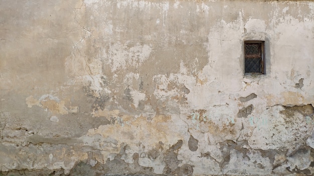 Vintage background. Loft. Plaster. Old painted wall with window. Vintage facade texture