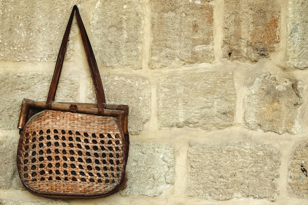 Una borsa vintage appesa al muro di pietra al mercato dell'antiquariato locale