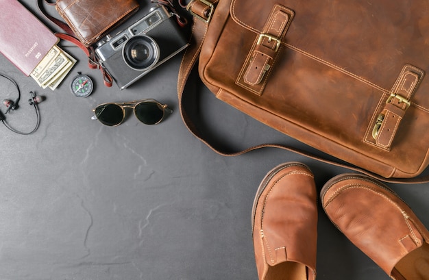 Vintage bag and leather boot shoe on black stone 