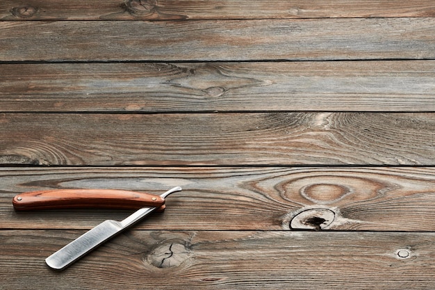 Vintage barber shop straight razor tool on wooden background