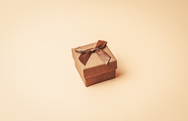 Vintage beige box with brown ribbon on a beige