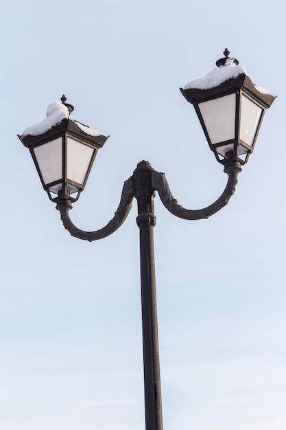 Vintage black street lamppost with two lamps in winter