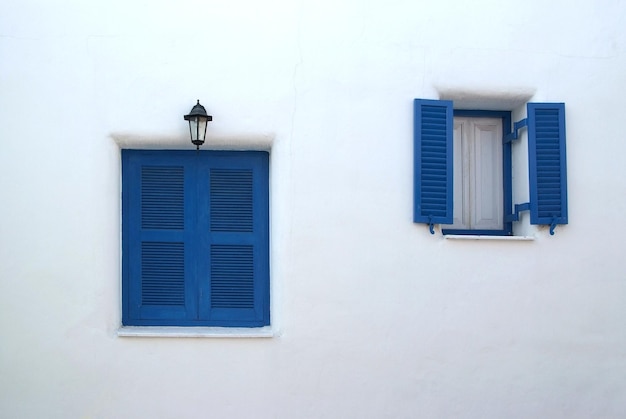 白い壁にヴィンテージの青い窓