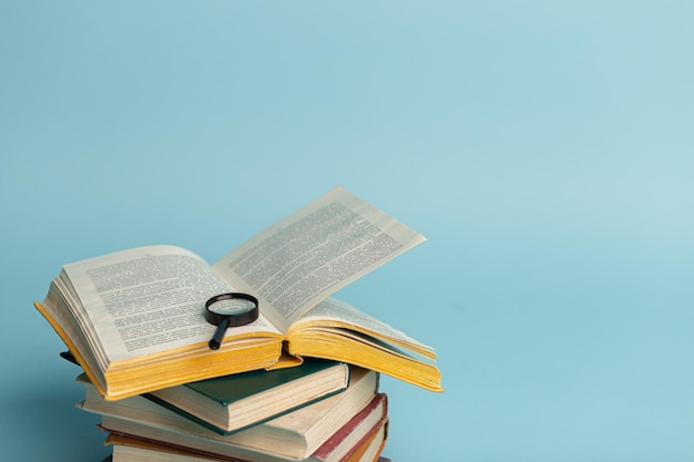 Vintage boek en vergrootglas op lichtblauwe achtergrond Onderwijsachtergrond Wereldboekendag