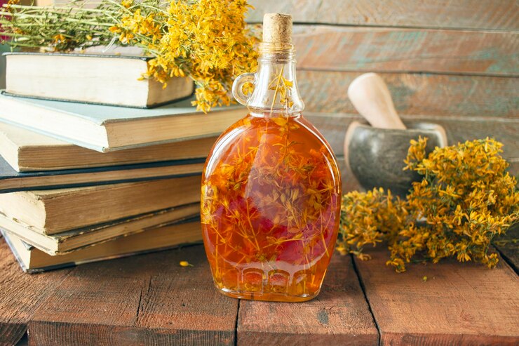 Photo vintage books dried st johns wort flowers and bottles of st johns wort oil