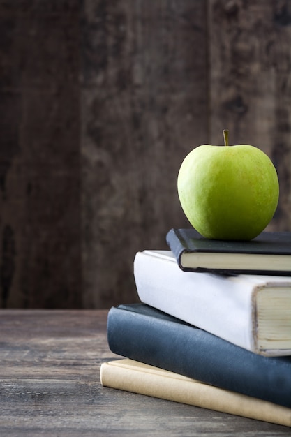 Vintage books with an apple on a wooden table