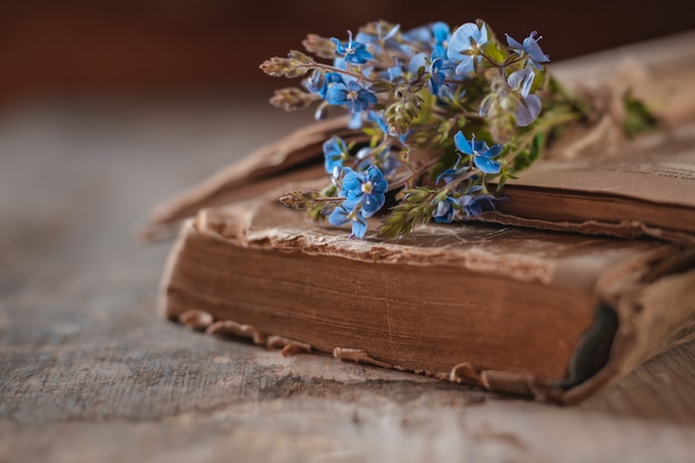 Vintage books with a bouquet of spring wildflowers