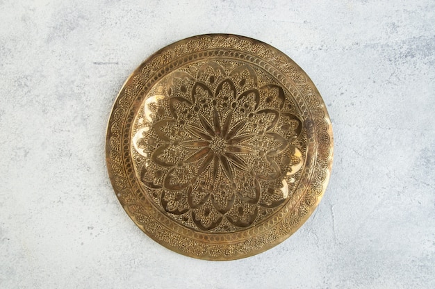 Vintage brass plate with embossed floral pattern