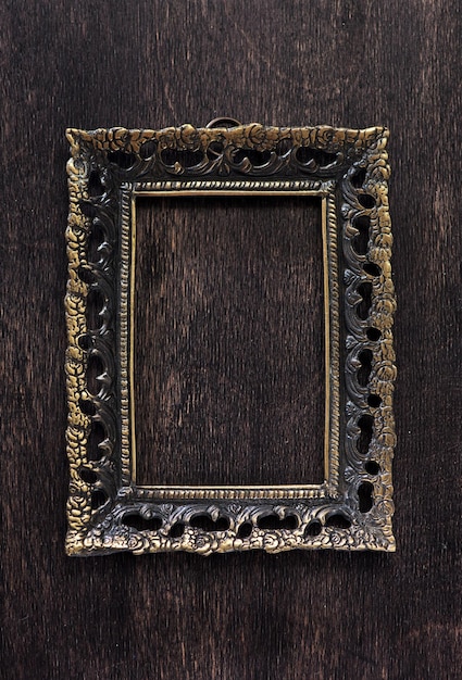 Vintage bronze frame on a wooden background top view