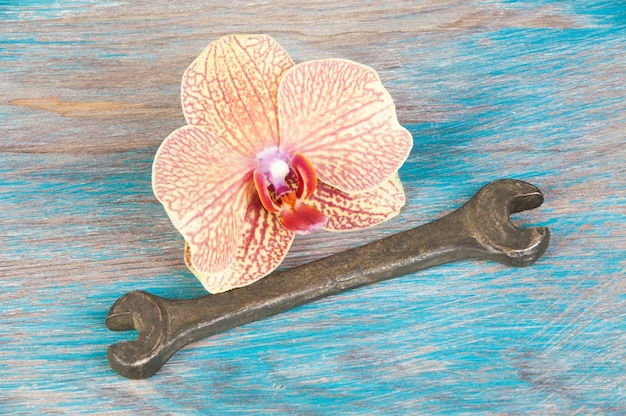 Vintage bronze wrench on shabby blue wooden background. Copy space for text.