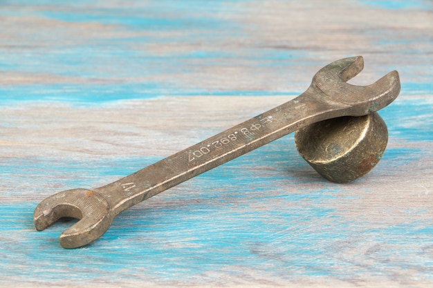 Vintage bronze wrench on shabby blue wooden background. Copy space for text.