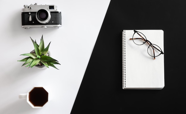 Vintage camera coffee cup glasses and notepad flat lay