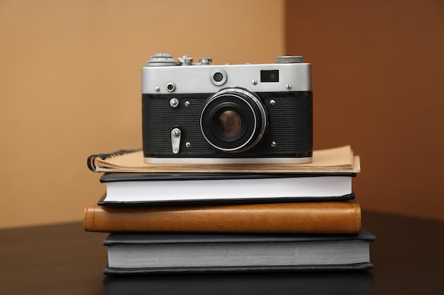 Vintage camera en blocnotes op houten tafel op bruine achtergrond