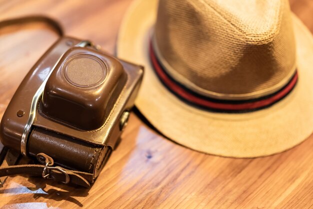 Vintage camera en een hoed op een tafel reisfotografie concept digitale nomade leven digitale inhoud maker filmcamera en een strooien hoed