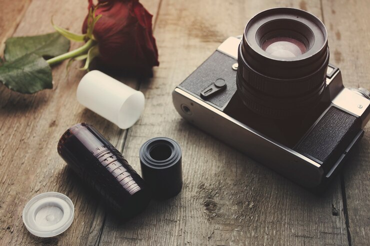 Vintage camera en roos op houten tafel