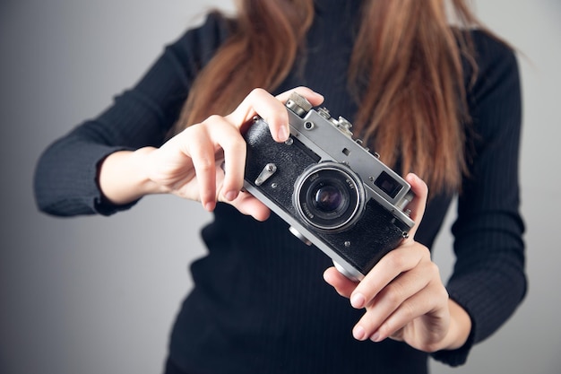 Vintage Camera in female hand on grey background