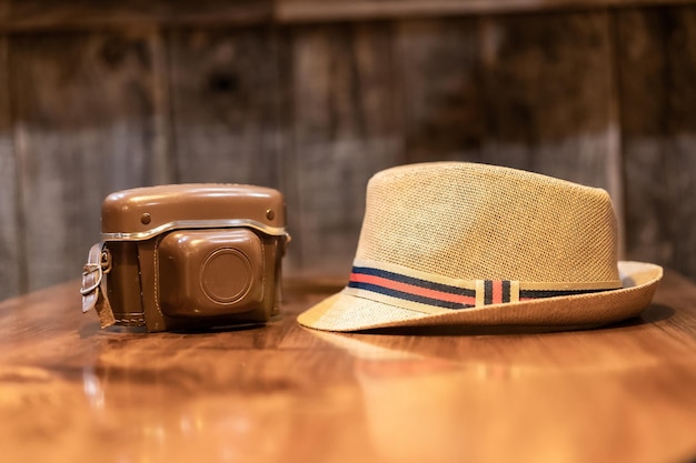 Vintage camera and a hat on a table travel photography concept digital nomad life digital content creator film camera and a straw hat