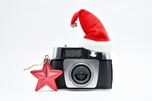 Vintage camera omgeven door kerstboom en speelgoed op geïsoleerde witte ruimte