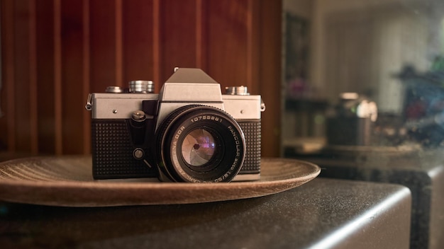 Vintage camera op een bruine tafel en daarachter een weerspiegeling ervan