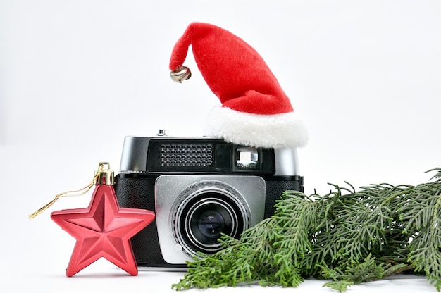 Vintage camera surrounded by christmas tree and toys on isolated white space