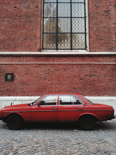 Фото Старый автомобиль на улице против здания