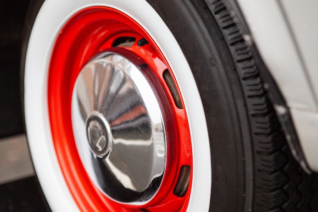 Vintage car wheel, painted red, the concept of the history of the development of cars.