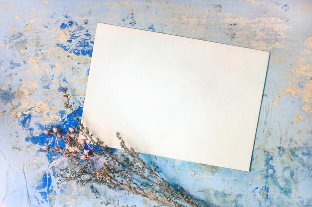 写真 古い田舎風の青い木製の背景にコピーテキストと乾燥した花の場所を持つヴィンテージカード