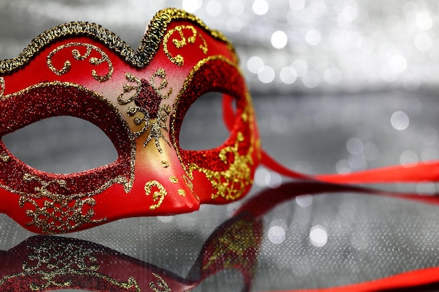 Vintage carnival mask in front of glittering background