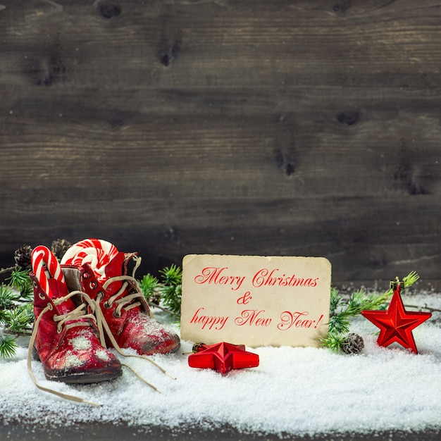 Stelle rosse della decorazione di natale dell'annata e fondo di legno delle scarpe da bambino antiche