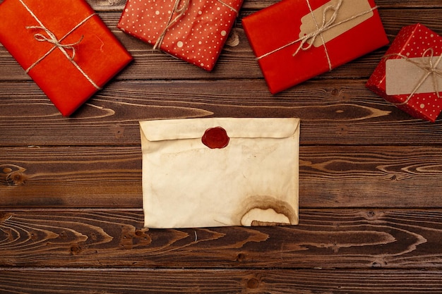 빈티지 크리스마스 인사말 편지와 나무 배경에 포장된 선물 상자