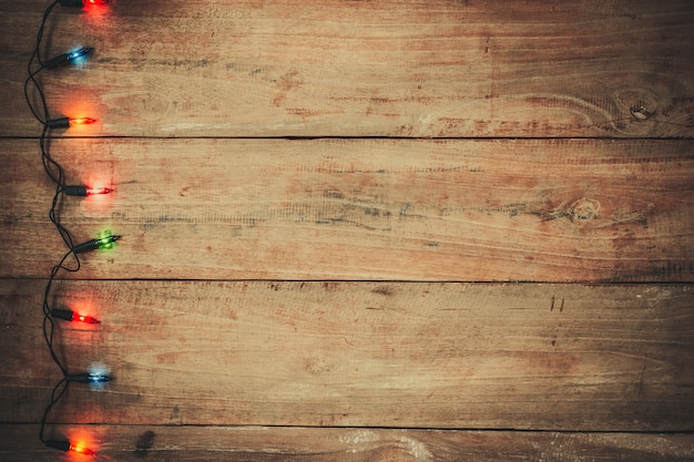 Vintage Christmas lights bulb decoration on old wood plank. 