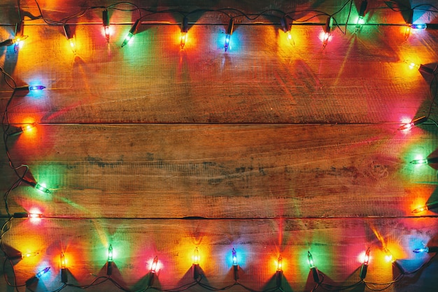 Vintage Christmas lights bulb decoration on old wood plank. 