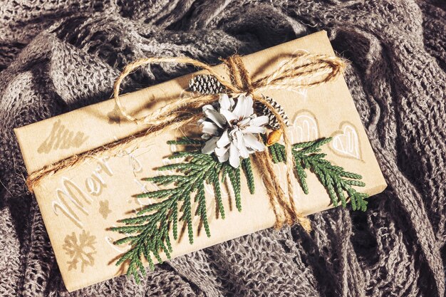 Vintage Christmas presents with gift box decorated with pine cones and twigs on on a cotton fabric