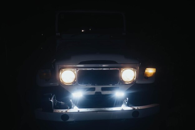 A vintage or classic offroad vehicle or fullsized SUV at night