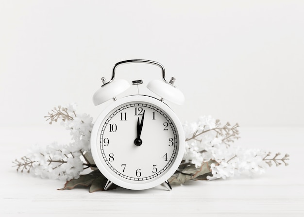 Photo vintage clock with white flowers