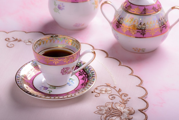Винтажная кофейная чашка над розовым мрамором
