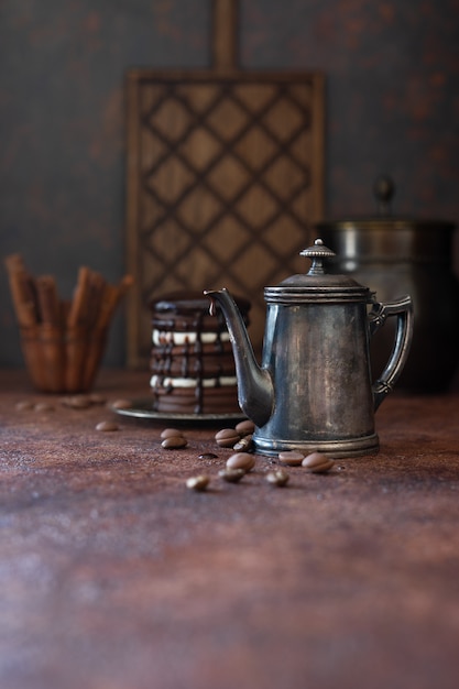 Vintage coffee pot and chocolate drops on dark background