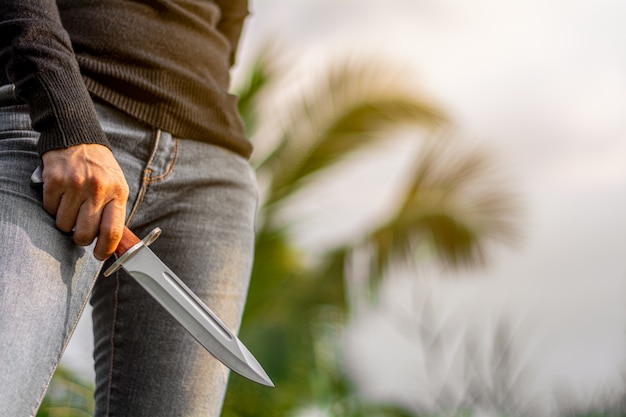 Vintage combat knife bayonet in women's hand. - Violence and crime concept.