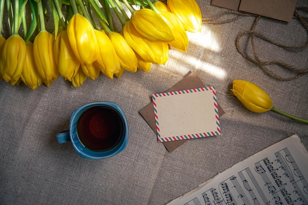 一杯のお茶のチューリップとノートフラットレイのヴィンテージ構成