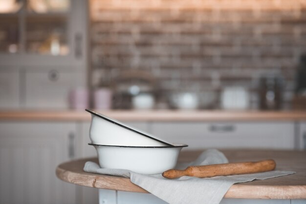 Vintage cooking bowls with rolling pin on kitchen table closeup Rustic style