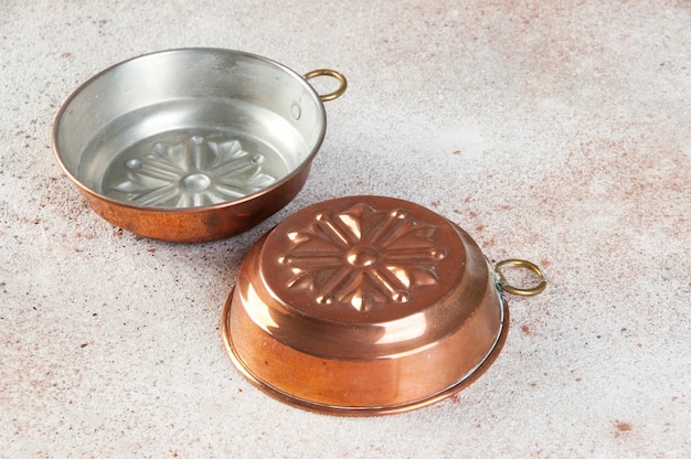 Vintage copper molds on a concrete background.