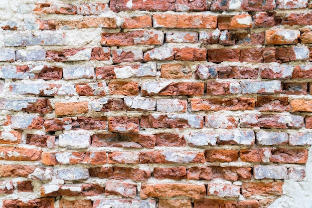 Vintage cracked red brick and concrete wall