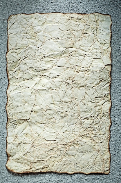 Vintage crumpled paper on grey surface vertical view.