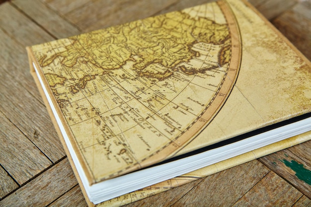 Photo vintage eastern hemisphere map on antique book cover rustic wooden texture