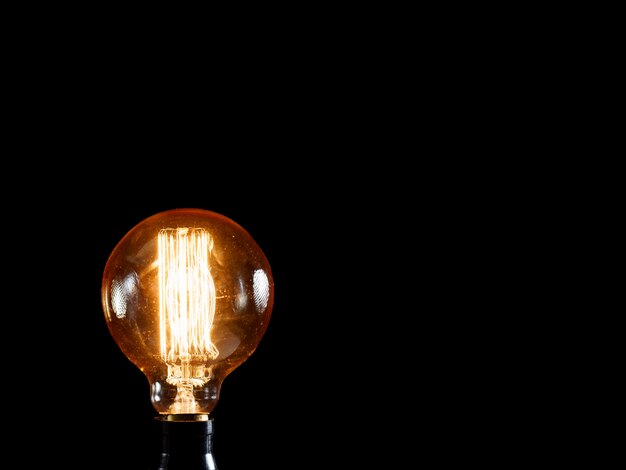 Винтажная лампа эдисона в темноте. креативная идея концепции.